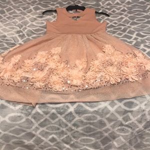 A pink dress with flowers and a charm.